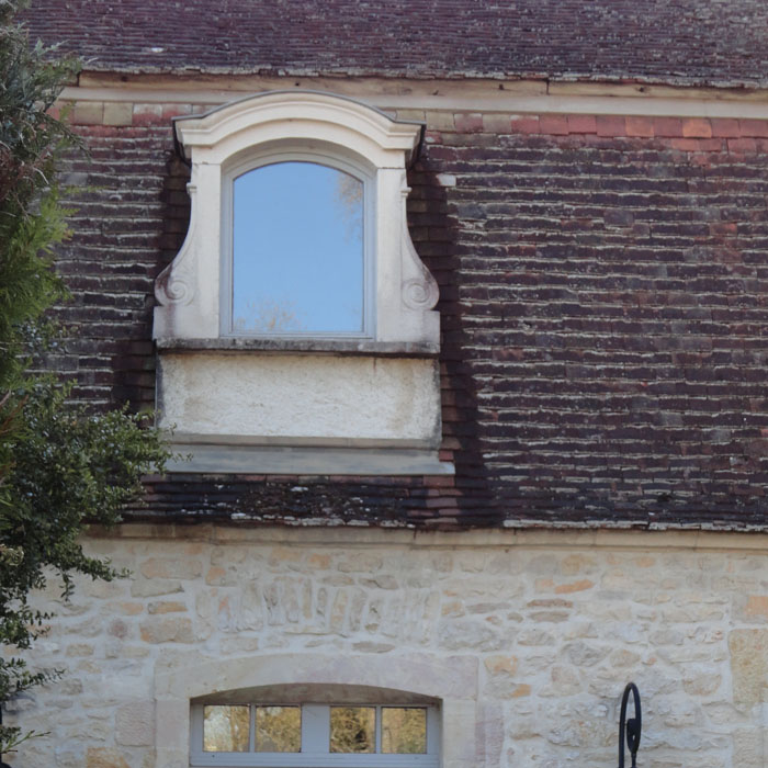 lucarne a chapeau de gendarme et jambage escargot en pierre reconstituee