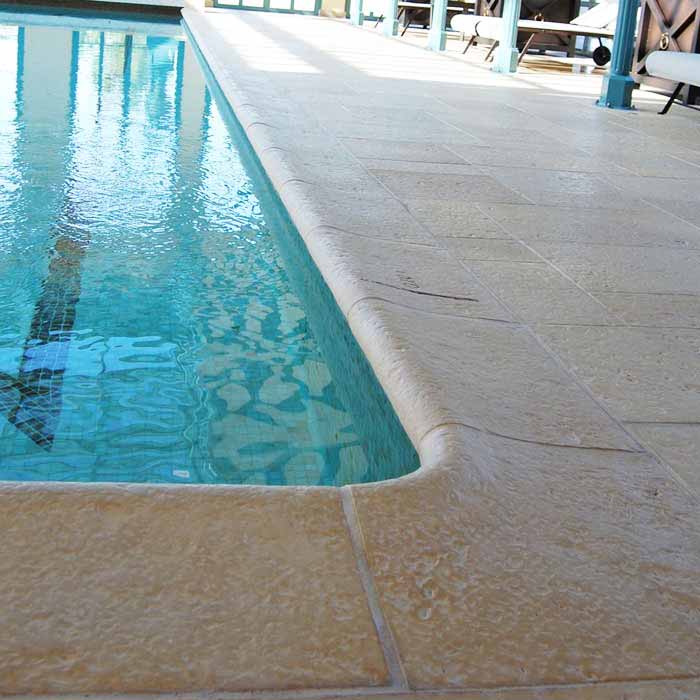 piscine avec margelle pierre reconstituée bouchardée galbée