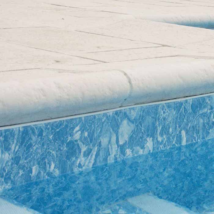bord piscine avec margelle pierre reconstituée bouchardée galbée