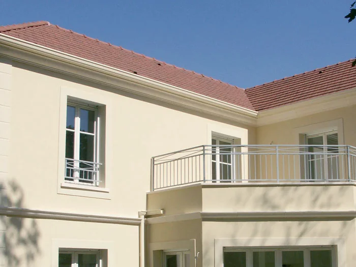 Corniches bandeau sous le toit et au niveau d'un balcon, façade claire