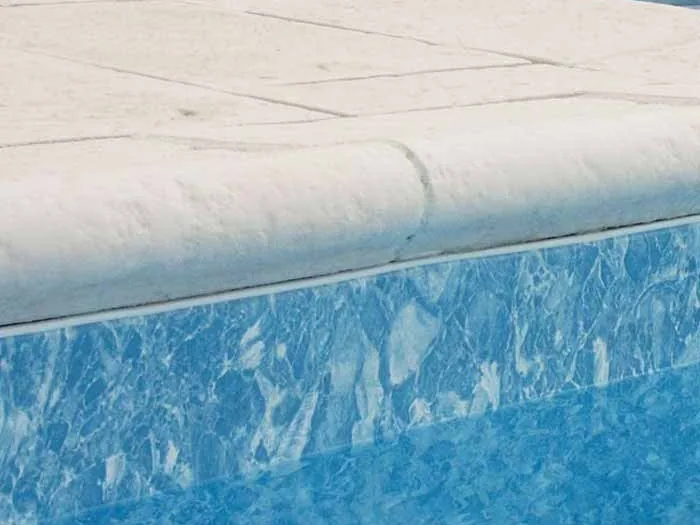 Bord galbé d'une margelle au-dessus de l'eau