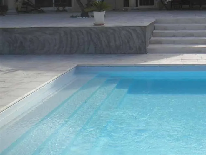 Margelles patinées le long des marches d'une piscine